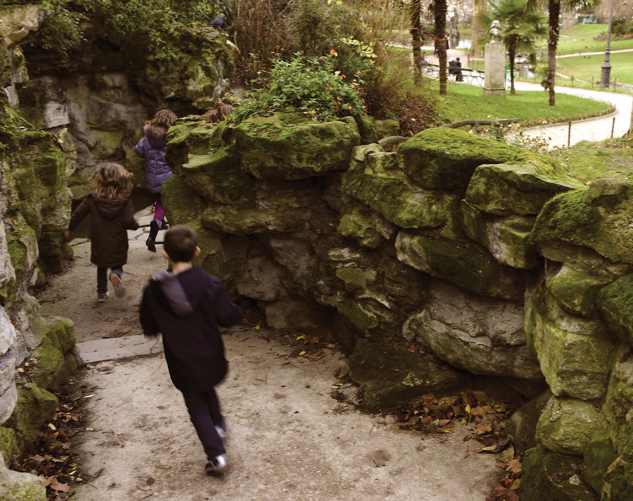 Kids running down an alley in the Parc des Batignolles in Paris