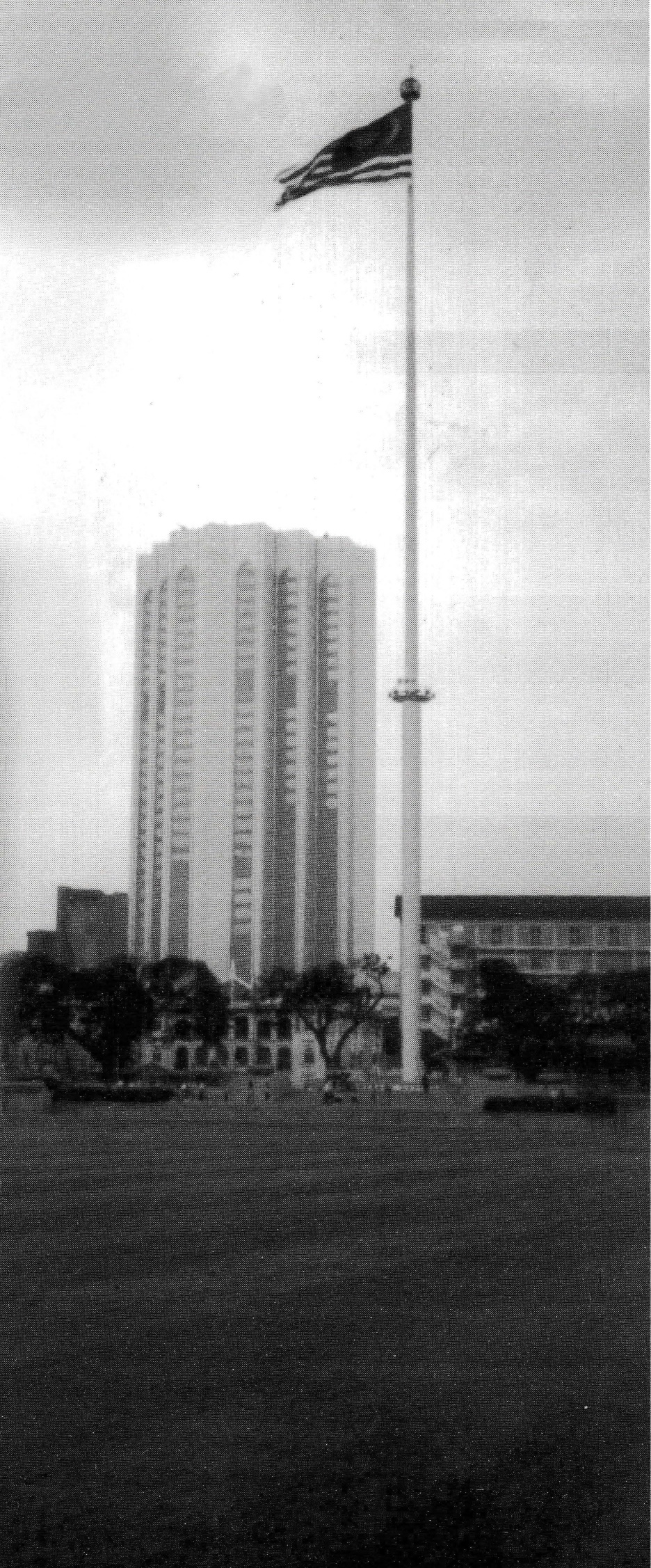 Image of a large flagpole next to a building